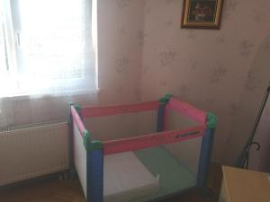 a toy crib in a room with a window at Chez Olivier et Josette sur Mulhouse Sud in Illfurth