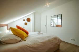 um quarto com uma cama grande com almofadas amarelas e laranja em The Azalea beautiful quiet apartment for 4 people! em Doussard