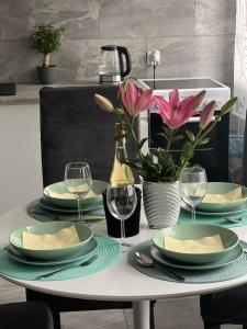 a table with plates and wine glasses and flowers at Apartament Dolny Śląsk in Wałbrzych