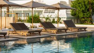 a group of lounge chairs and umbrellas next to a pool at Royal Azur Thalassa in Hammamet