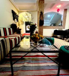 a living room with a table with a bowl of fruit on it at Riad Les Miroirs in Marrakech