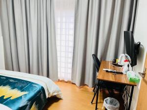 a bedroom with a bed and a desk with a television at 福宿 Fukuinn 201号室 in Takamatsu
