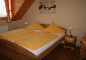 a bedroom with a large bed with yellow pillows at Zur Rotenfelsstube in Traisen +8 photos
