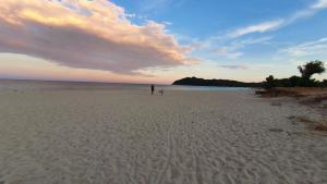 a person walking on the beach at sunset at Civico Otto7 in Villasimius