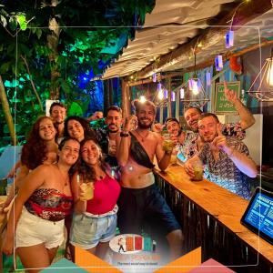 un grupo de personas posando para una foto en un bar en Vila Pepouze Hostel, en Morro de São Paulo