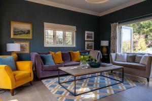 sala de estar con sofá púrpura y sillas amarillas en The Lodge en New Milton