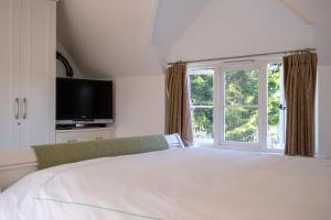 une chambre avec un grand lit blanc et une fenêtre dans l'établissement The Lodge, à New Milton 54 autres photos