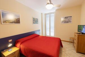 um quarto com uma cama vermelha e uma televisão em Residenza IL CASTELLO em Sondrio