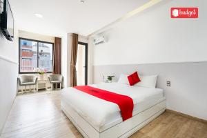 Schlafzimmer mit einem weißen Bett mit roten Akzenten in der Unterkunft Khanh Linh Hotel in Vũng Tàu