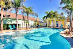 a swimming pool with palm trees in a resort at Marquesas #310 in Padre Island