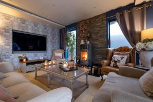 a living room with a table and a fireplace at Deer Lodge in Lymington