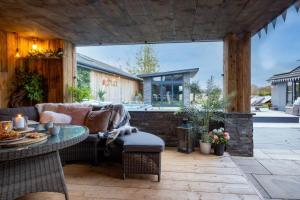 an outdoor patio with a couch and a table at Deer Lodge in Lymington