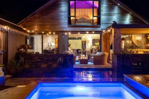 a swimming pool in front of a house at night at Deer Lodge in Lymington