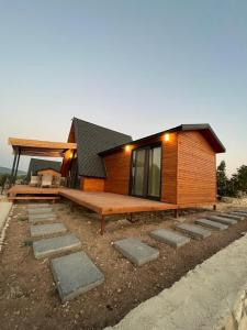 a small house with a wooden floor and a porch at Nefes URLA Bungalov 2 in Urla
