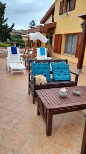 eine Terrasse mit 2 Liegestühlen und einem Tisch in der Unterkunft B&B Villa Sul Golfo in Quartu SantʼElena