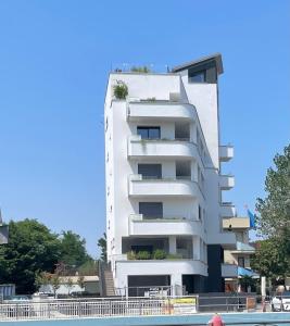 un edificio bianco con una piscina di fronte di La Torre del Porto a Riccione