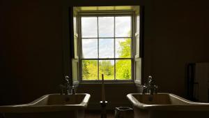 a bathroom with two sinks in front of a window at Boath House Hotel in Nairn