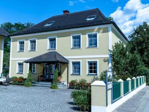 a large yellow house with a black roof at Appartementhof Stadler in Pocking