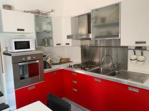 a kitchen with red cabinets and a microwave at Spacious 2 bedroom condo in Colletta