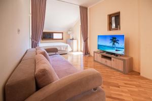 a living room with a couch and a flat screen tv at Boka Apartment in Baošići