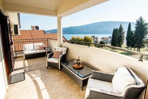 a balcony with furniture and a view of the water at Boka Apartment in Baošići