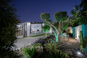 a house with a tree in the yard at night at Villa Mamba By Seric,15' walking to the beach in Torremolinos