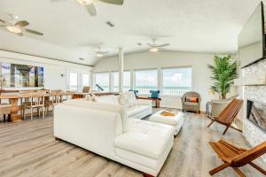 uma sala de estar com mobiliário branco e uma lareira em Salty Sandpiper em Galveston