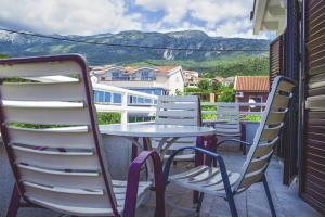 a table and chairs on a balcony with mountains in the background at Vera Apartments in Budva