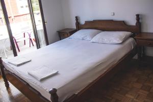 Una cama con sábanas blancas y almohadas blancas. en Vera Apartments, en Budva