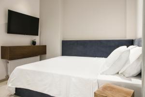 a bedroom with a white bed and a flat screen tv at Ultra Chic Modern 4 Bedrooms Apartment in Athens in Athens