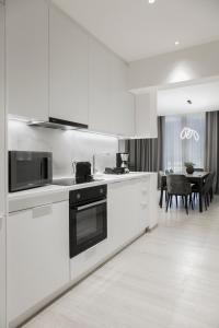 una cucina con elettrodomestici bianchi e una sala da pranzo di Ultra Chic Modern 4 Bedrooms Apartment in Athens ad Atene