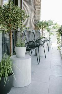 un patio con tavoli, sedie e piante in vaso di Ultra Chic Modern 4 Bedrooms Apartment in Athens ad Atene