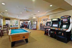 a room with a pool table and arcade games at Family Fiesta in Orlando