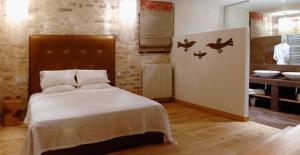 a bedroom with a bed with two birds on it at Au Vieux Moulin in Chablis