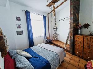 sypialnia z łóżkiem, komodą i oknem w obiekcie La Casita del acantilado w mieście Puerto de la Madera
