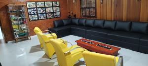 uma sala de espera com cadeiras amarelas e um sofá em Casa Campo Bragança em Bragança Paulista