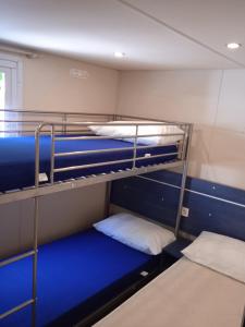 a room with two bunk beds with blue sheets at Mobile home Ameglia - Including airco - Camping River- 328 in Ameglia