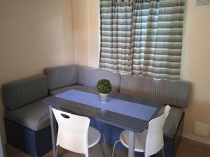阿梅利亞的住宿－Mobile home Ameglia - Including airco - Camping River- 328，一张桌子和椅子,配有一张蓝色的桌子和一张沙发