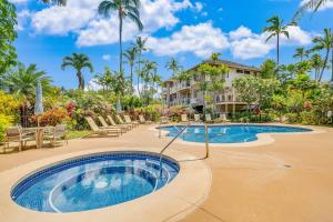 a pool at a resort with chairs and palm trees at Wailea Grand Champions 58 in Wailea