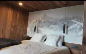 莫尔济讷Chalet avec jacuzzi - 150 m des remontées的卧室里有一张床，墙上挂着一幅画