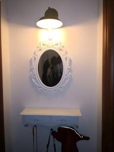 un espejo en una pared con una mesa y una luz en L' incantevole Tana di Oto en Ovindoli