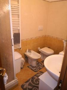 a bathroom with two toilets and a sink at L' incantevole Tana di Oto in Ovindoli