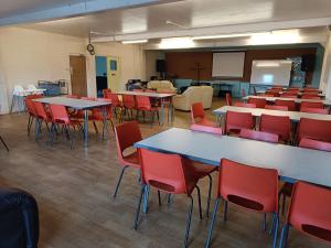 uma sala de aula com mesas e cadeiras e um quadro-negro em Y Doc at World Horizons Community Hub em Llanelli