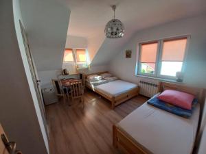 Habitación pequeña con 2 camas y mesa. en Pokoje Goscinne TOMASZ, en Międzywodzie