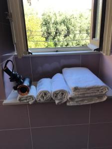 estante en el baño con toallas y ventana en Maison de Charme Iommella, en Sant'Agnello