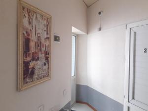 una camera con un dipinto sul muro e una finestra di Azimut a Jalal-Abad