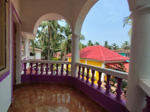 un balcón de una casa con techo rojo en Goa tour advisor & hospitality, en Candolim