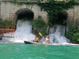 un grupo de personas en una canoa frente a una cascada en Adventure Land, en Jablanica