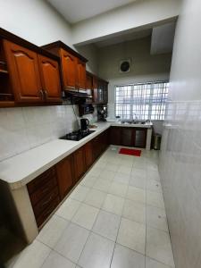 uma cozinha com armários de madeira e piso em azulejo branco em HOMESTAY DR. Z (MUSLIM HOMESTAY) em Klang