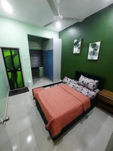 een slaapkamer met een groot bed in een groene muur bij HOMESTAY DR. Z (MUSLIM HOMESTAY) in Klang